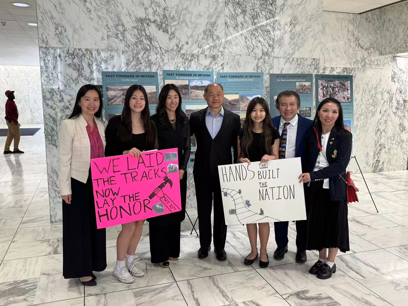 Joy and supporters holding May 10 signs at the Chinese railroad workers exhibition